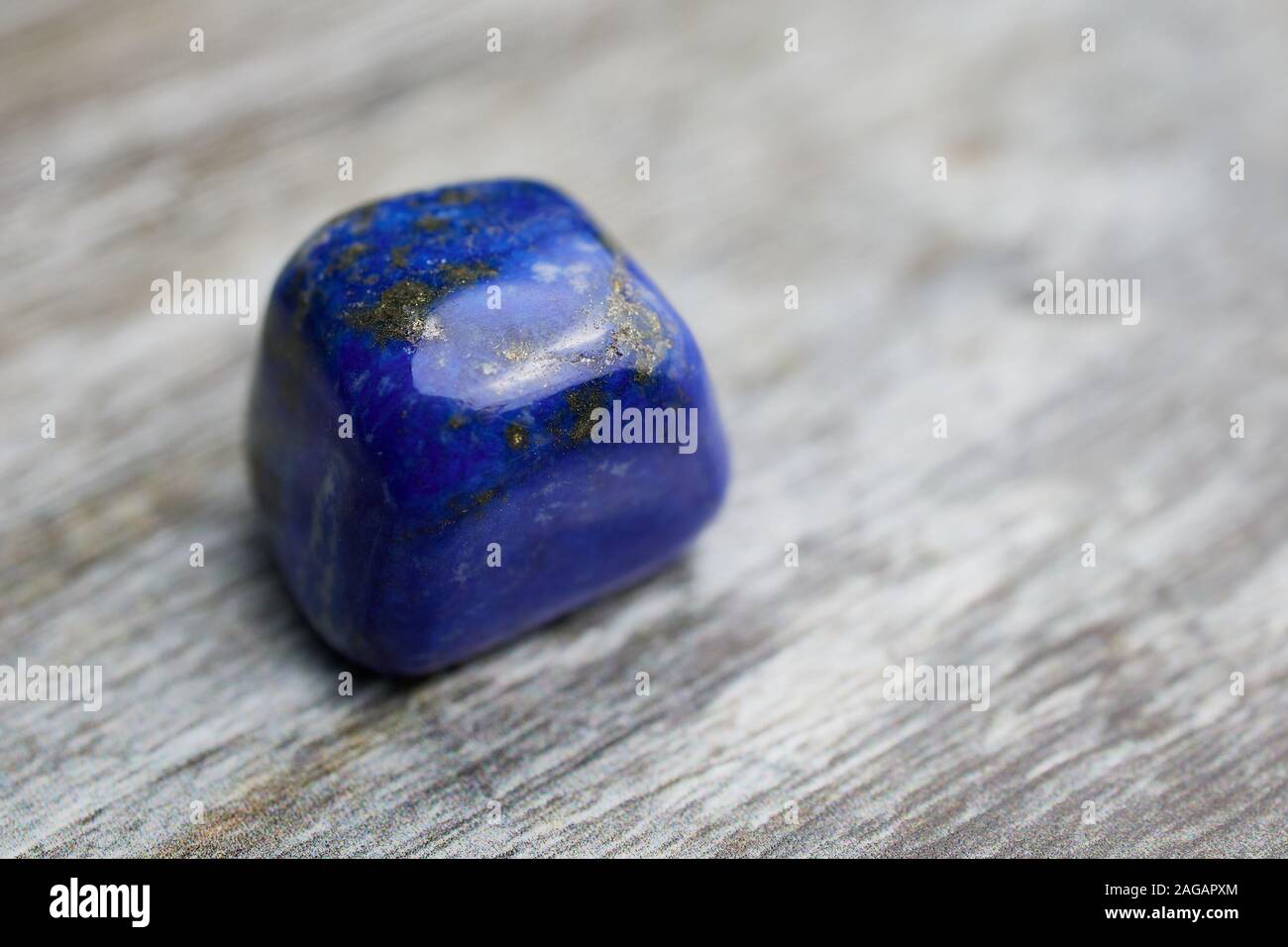 close up of blue gemstone lapis lazuli on wooden background with copy space Stock Photo