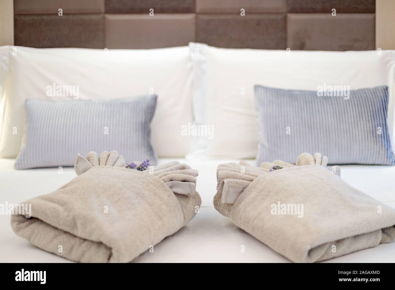 A King Size Bed With Two Folded Cozy Blankets And Blue Pillows
