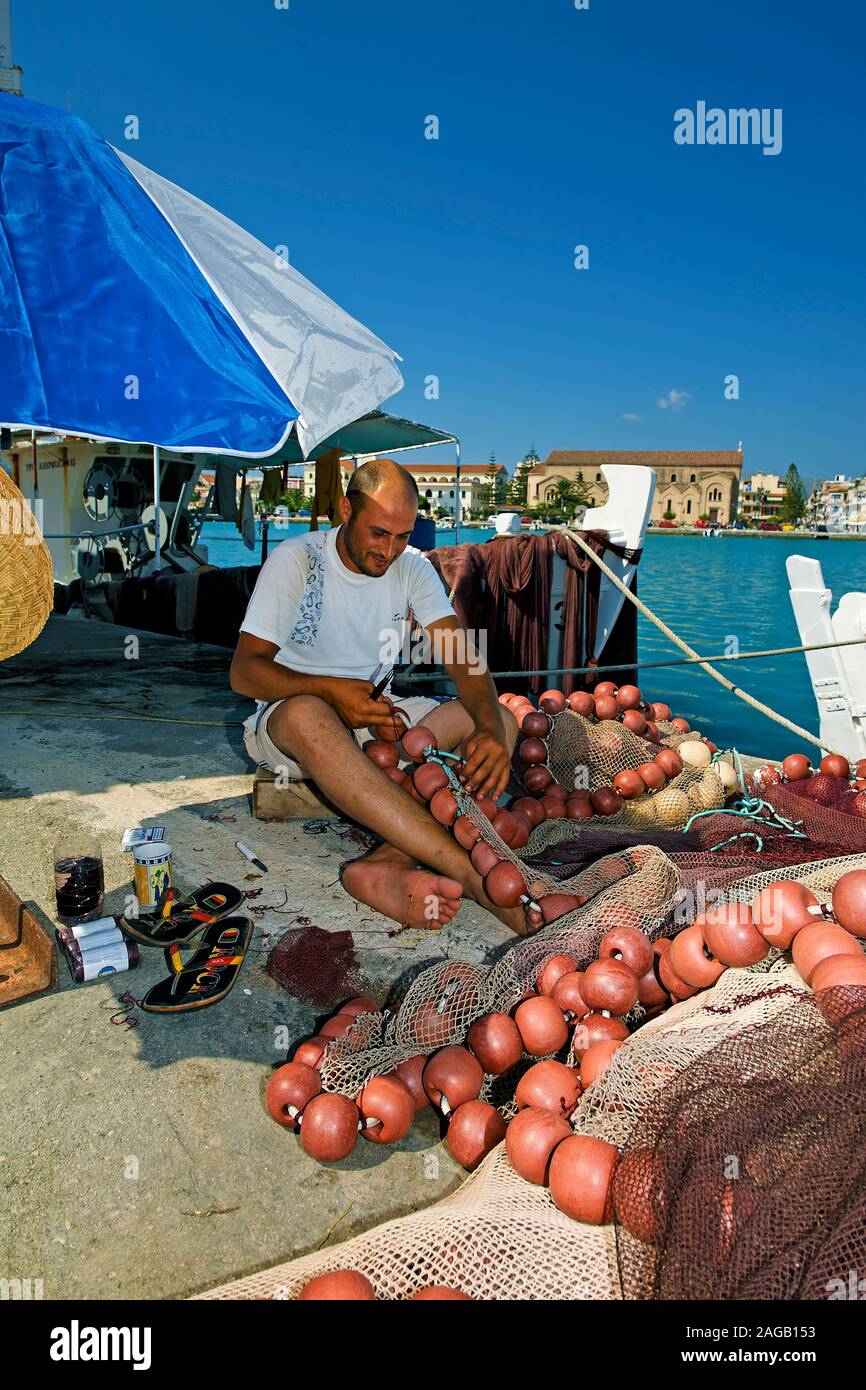 Fisherman repairing nets at the harbour of Zakynthos-town, Zakynthos island, Greece Stock Photo