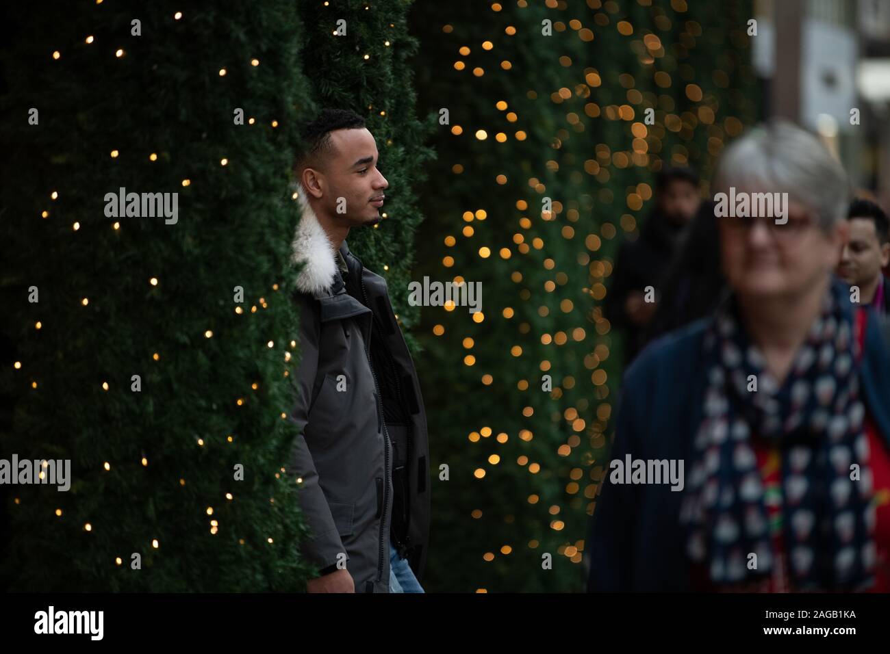Man posing between Christmas trees outside Selfridges Stock Photo