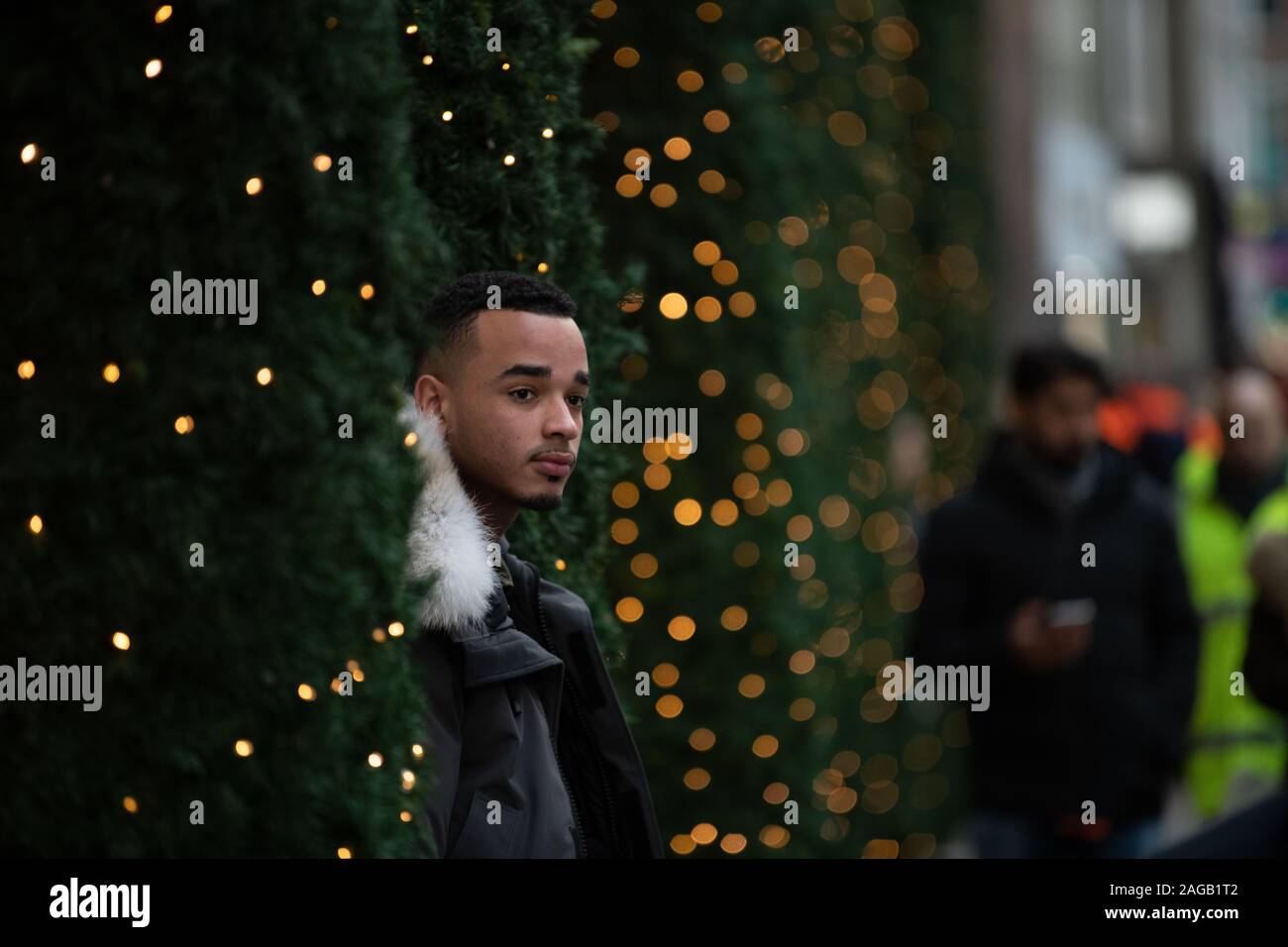 Man posing between Christmas trees outside Selfridges Stock Photo