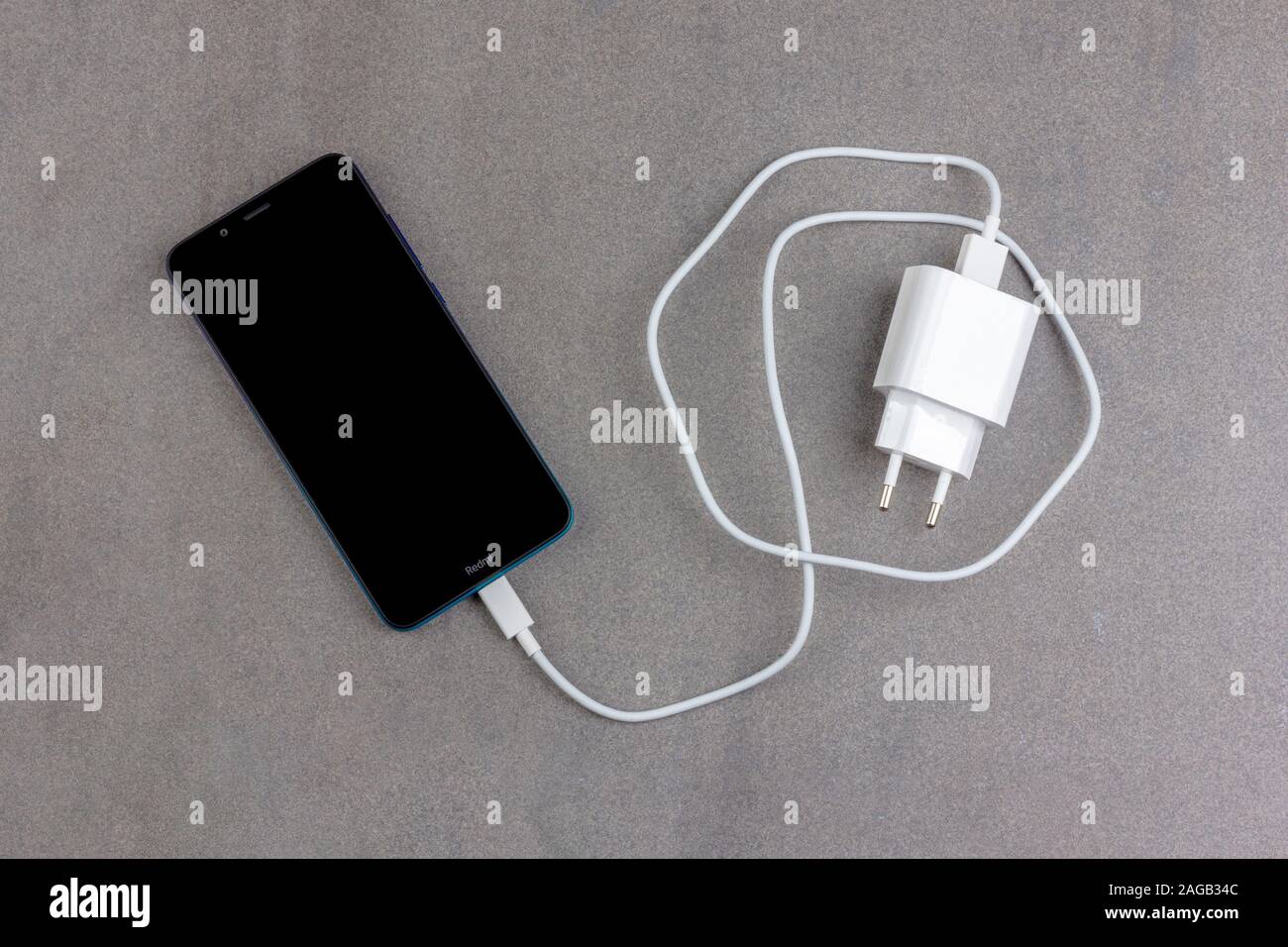 Krasnodar, Russia - November 23, 2019: chinese smartphone Xiaomi Redmi 7A  Gem Blue with black screen with white charger on gray background top view  cl Stock Photo - Alamy
