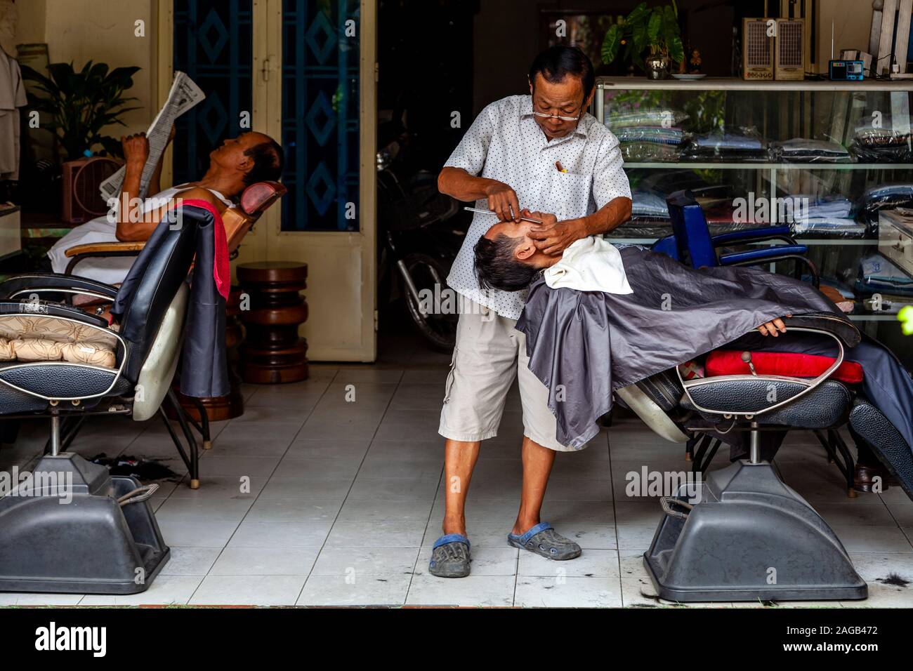 A Man Having A Wet Shave In A Barber Shop, Phnom Penh, Cambodia. Stock Photo