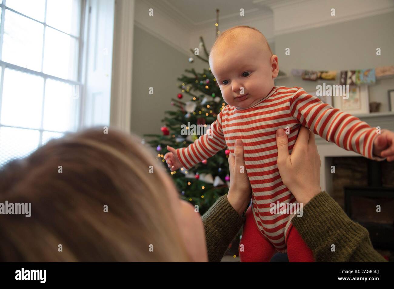 Cute happy baby wearing playing with mum at christmas Stock Photo