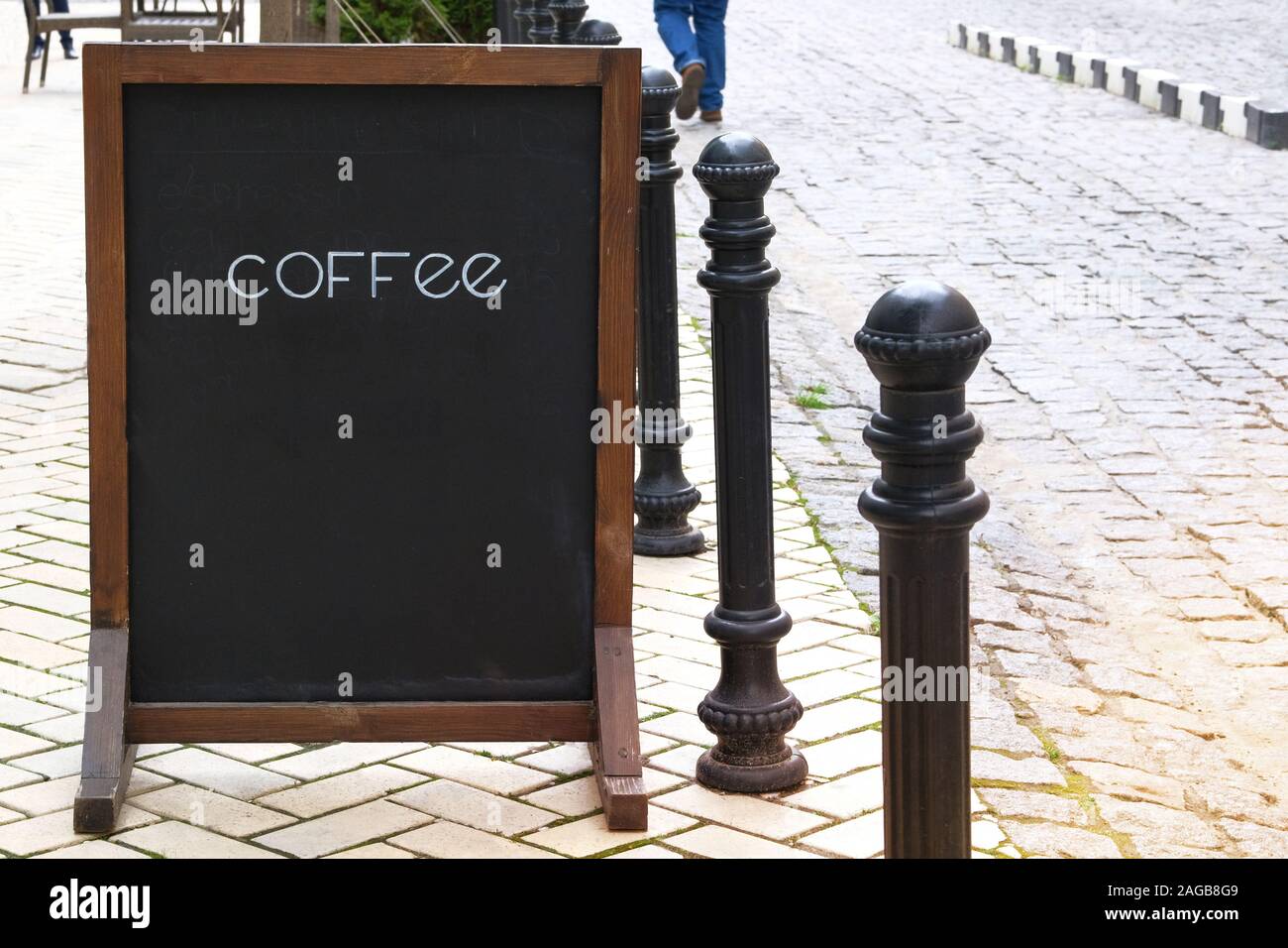 Chalk board menu black color with inscription – Coffee. Street in city. Sun. Stock Photo