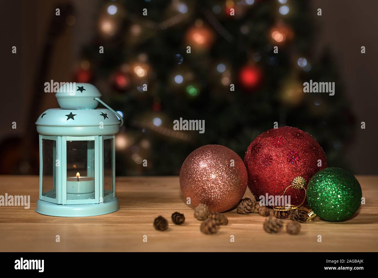 Holiday Christmas decoration. Festive decoration with lantern, pine cones, Christmas tree and ornaments on a wooden table Stock Photo