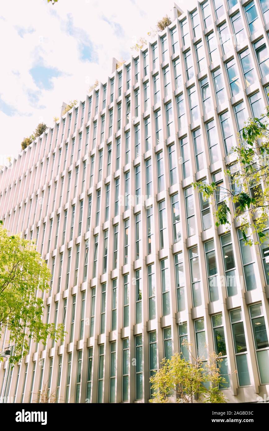 Vertical low angle shot of a concrete white building under the cloudy ...