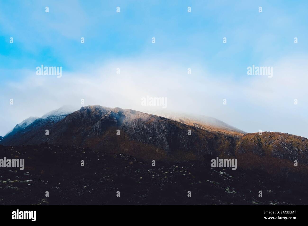 Cloud of smoke coming out of a mountainous scenery touching the sky Stock Photo