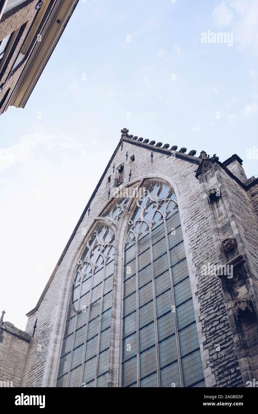 Vertical low angle shot of an old brick building under the cloudy sky ...