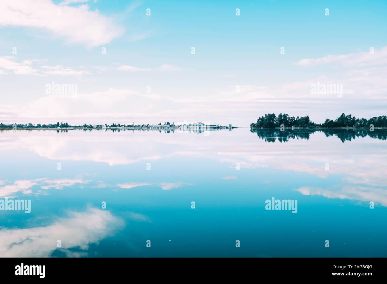 Beautiful scenery of a range of trees reflecting in the lake under the ...