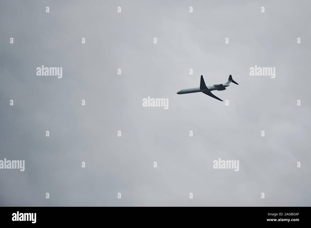 Passenger plane high up in the sky. Cloudy weather. Modern aviation Stock Photo