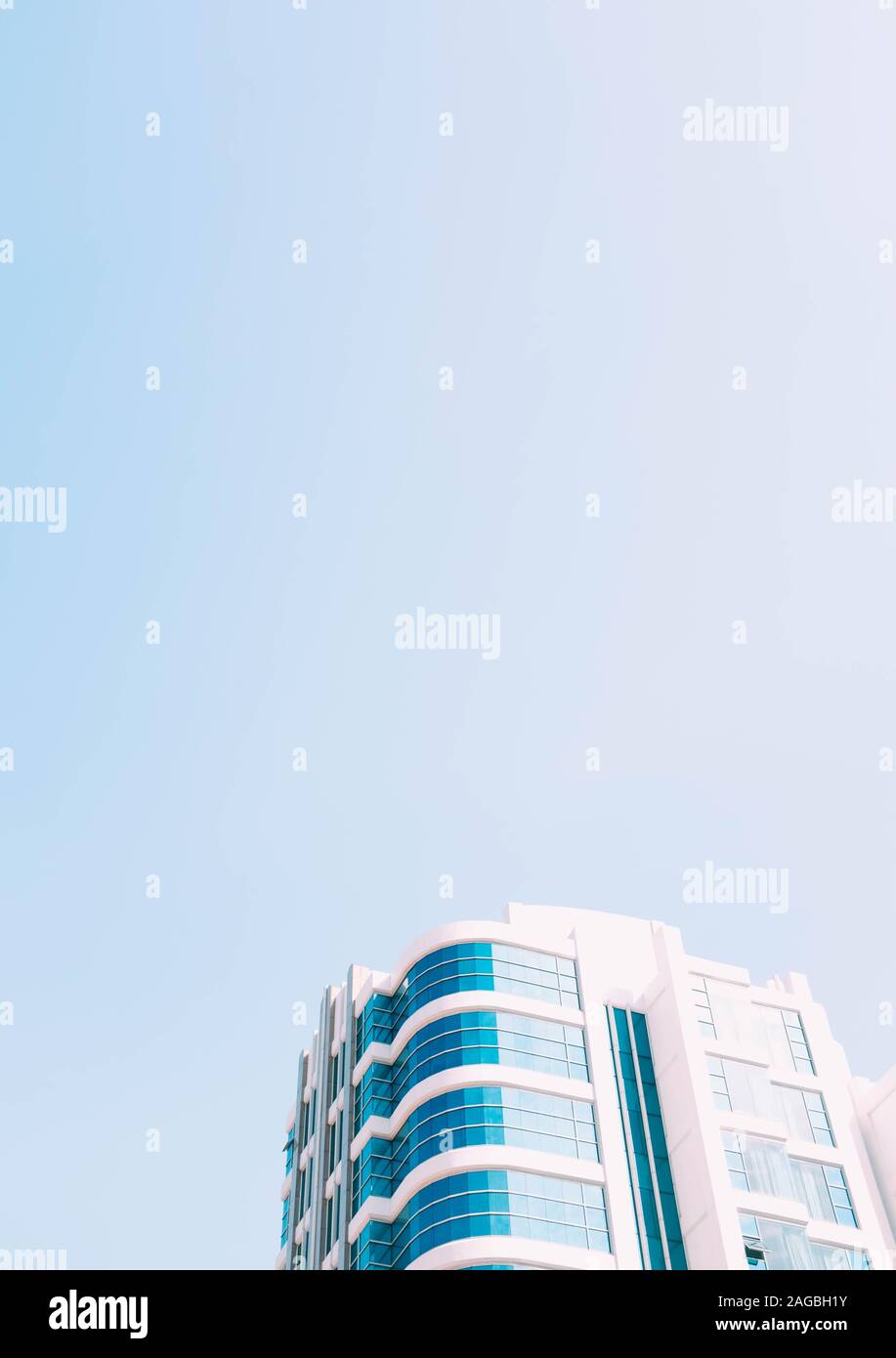 Vertical low angle shot of a glass building under the blue sky captured ...