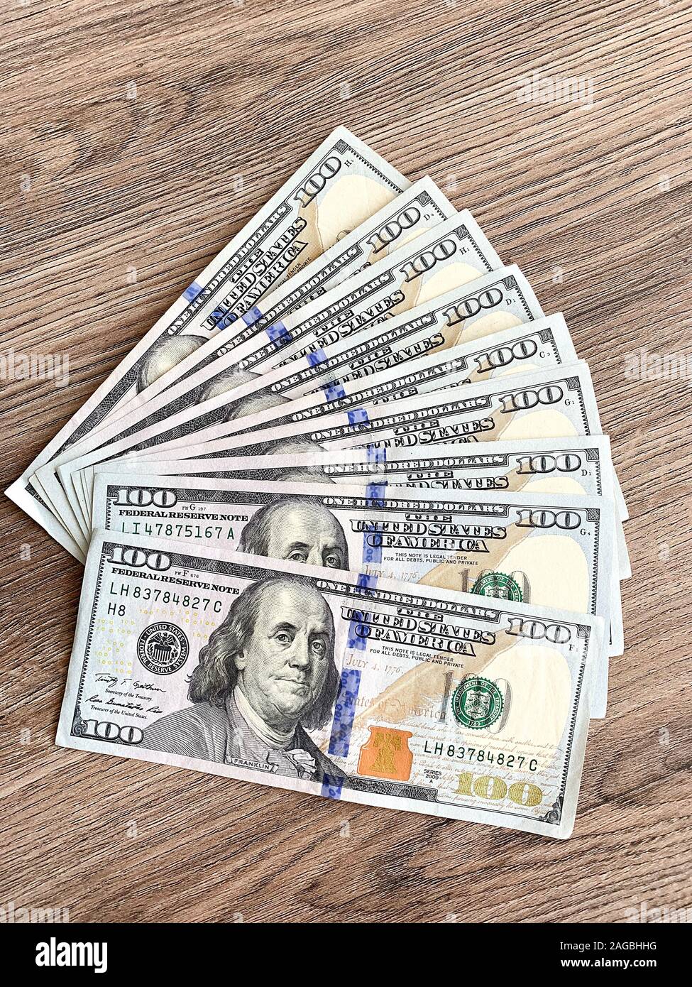 Stack of one hundred dollars bills on wooden desk Stock Photo Alamy