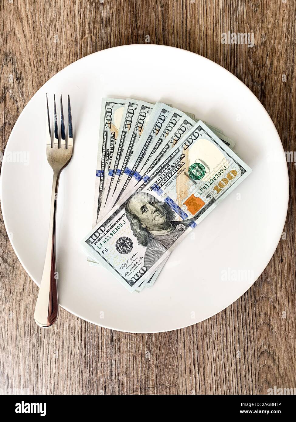 Money lying on the plate with fork. Dollars photo. Greedy corruption