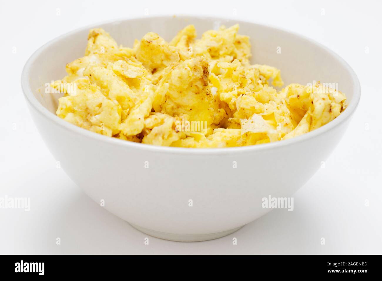 Scrambled eggs in white bowl on white background Stock Photo - Alamy