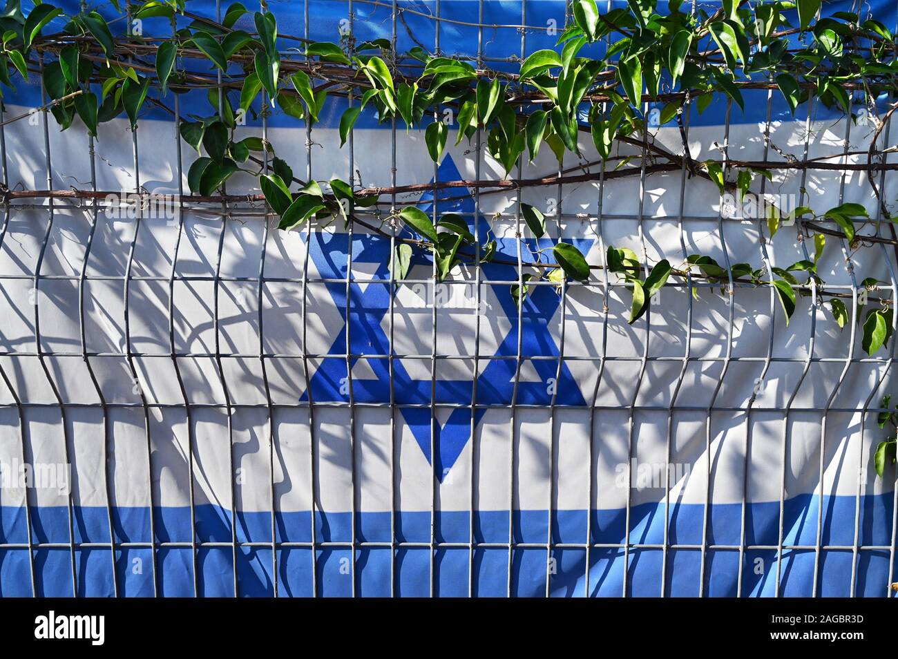 Israeli flag caught behind a fence Stock Photo