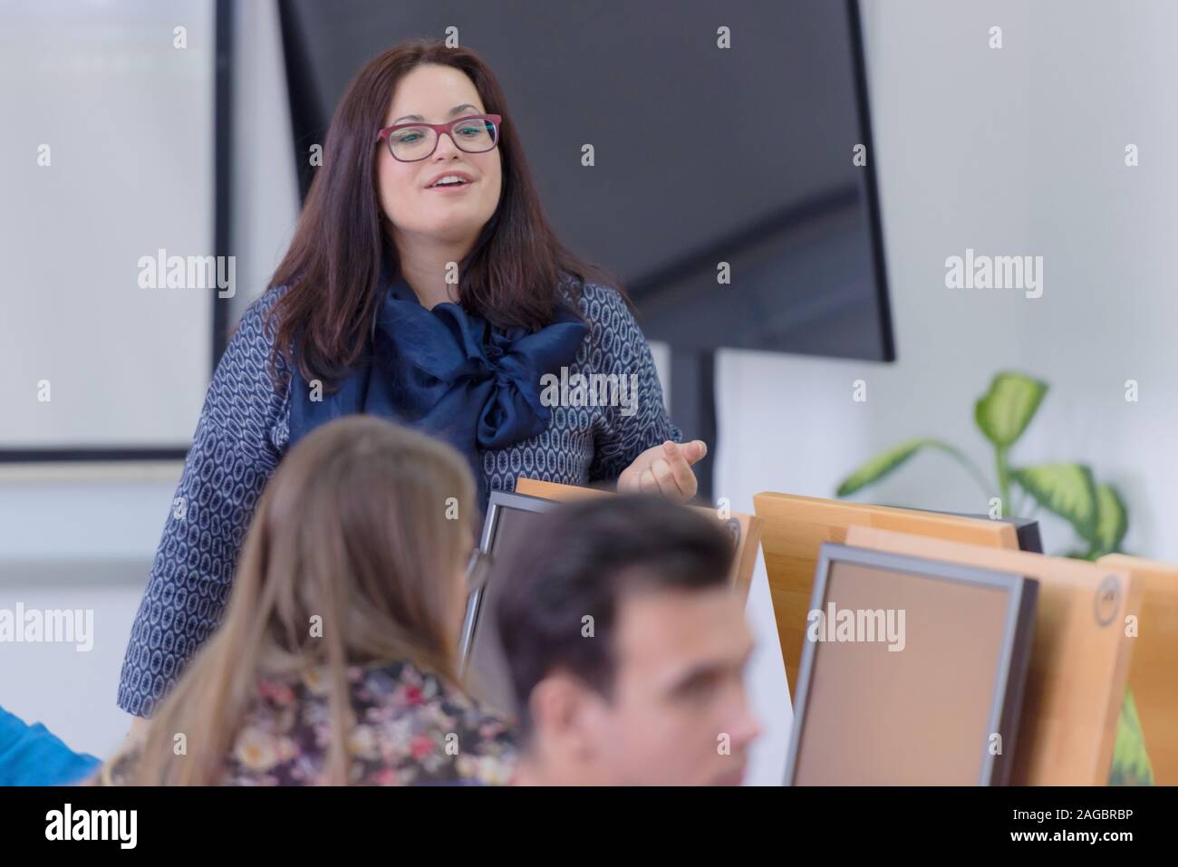 Female professor explain to students and interact with them in the ...