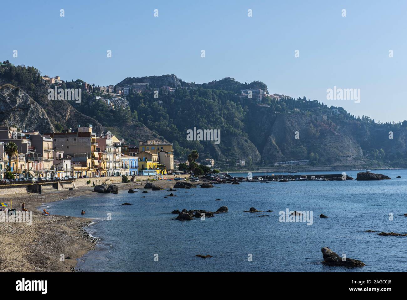 View of Taormina from Naxos with buildings, sea, boats and blue sky Stock Photo