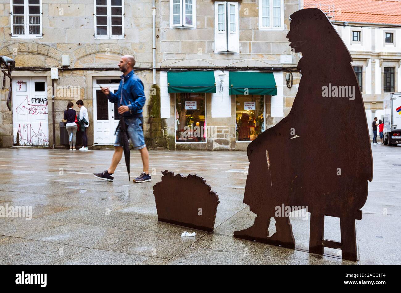 Pontevedra, Galicia, Spain : A man walk past the The Fiel Contraste sculpture by artist Ramón Conde inaugurated in 2010 at Alhondiga street in the old Stock Photo