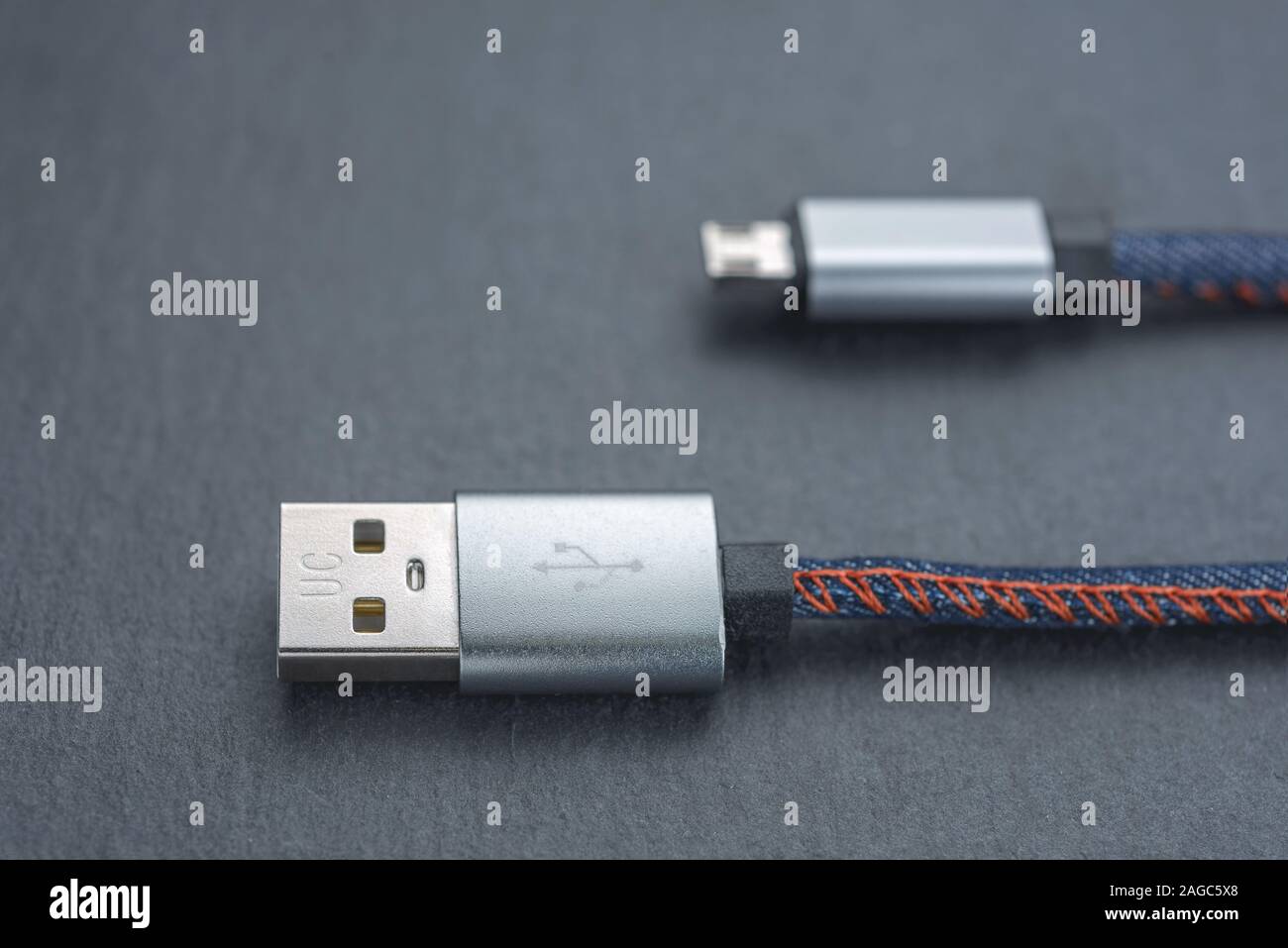 Micro USB cable with cable against a dark background.. Stock Photo