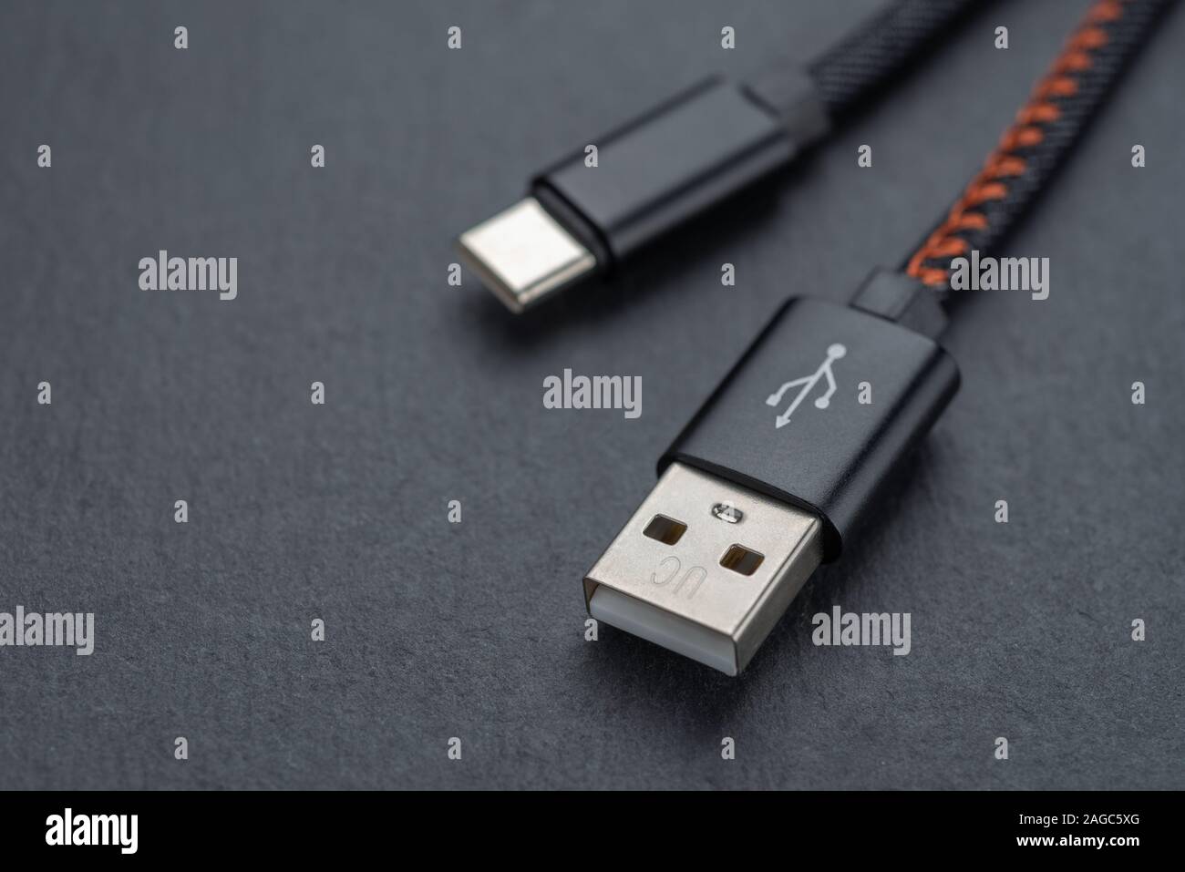 Type C USB cable with cable against a dark background.. Stock Photo