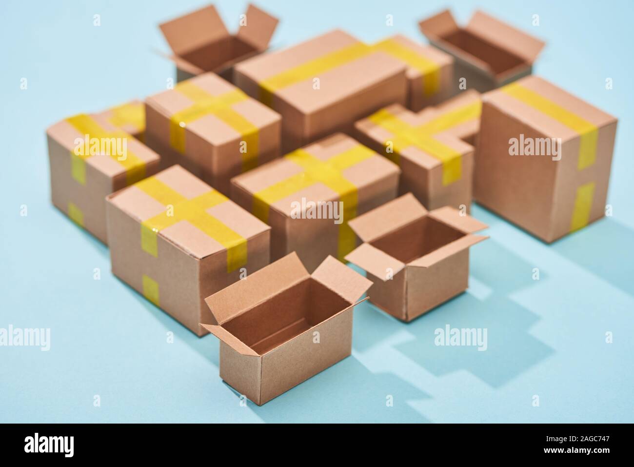 miniature cardboard postal boxes on blue background Stock Photo