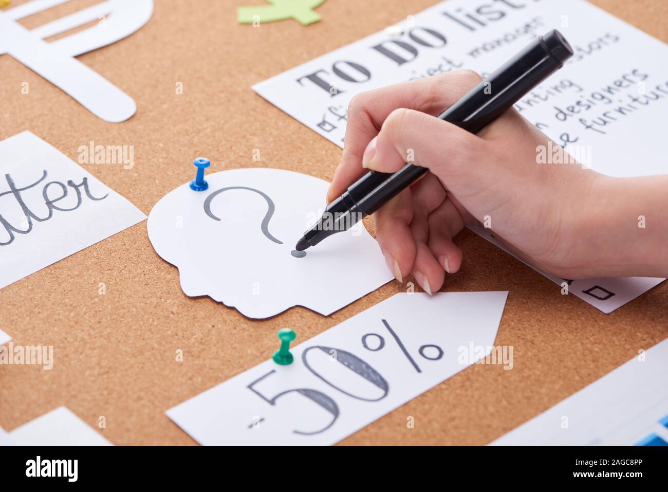 cropped view of woman writing question mark with black highlighter on