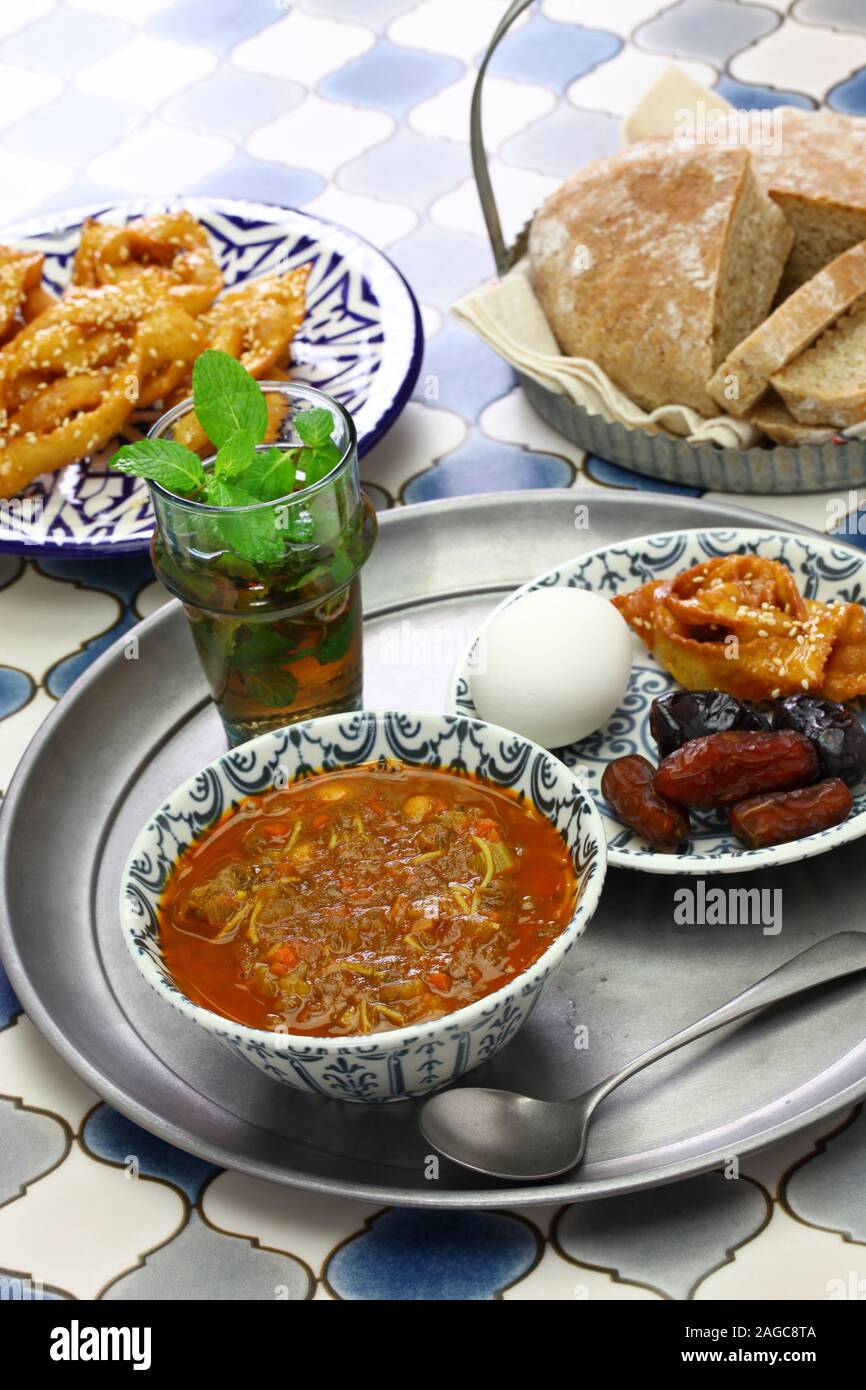 moroccan ramadan iftar meal, harira soup, chebakia, dates, mint tea and khubz Stock Photo