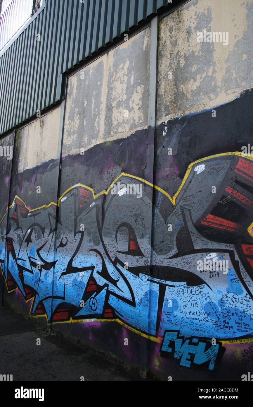 Colourful mural & graffiti on Peace wall, or Peace Line, running along Cupar Way in Belfast. It is one of the many separation barriers in N.Ireland Stock Photo