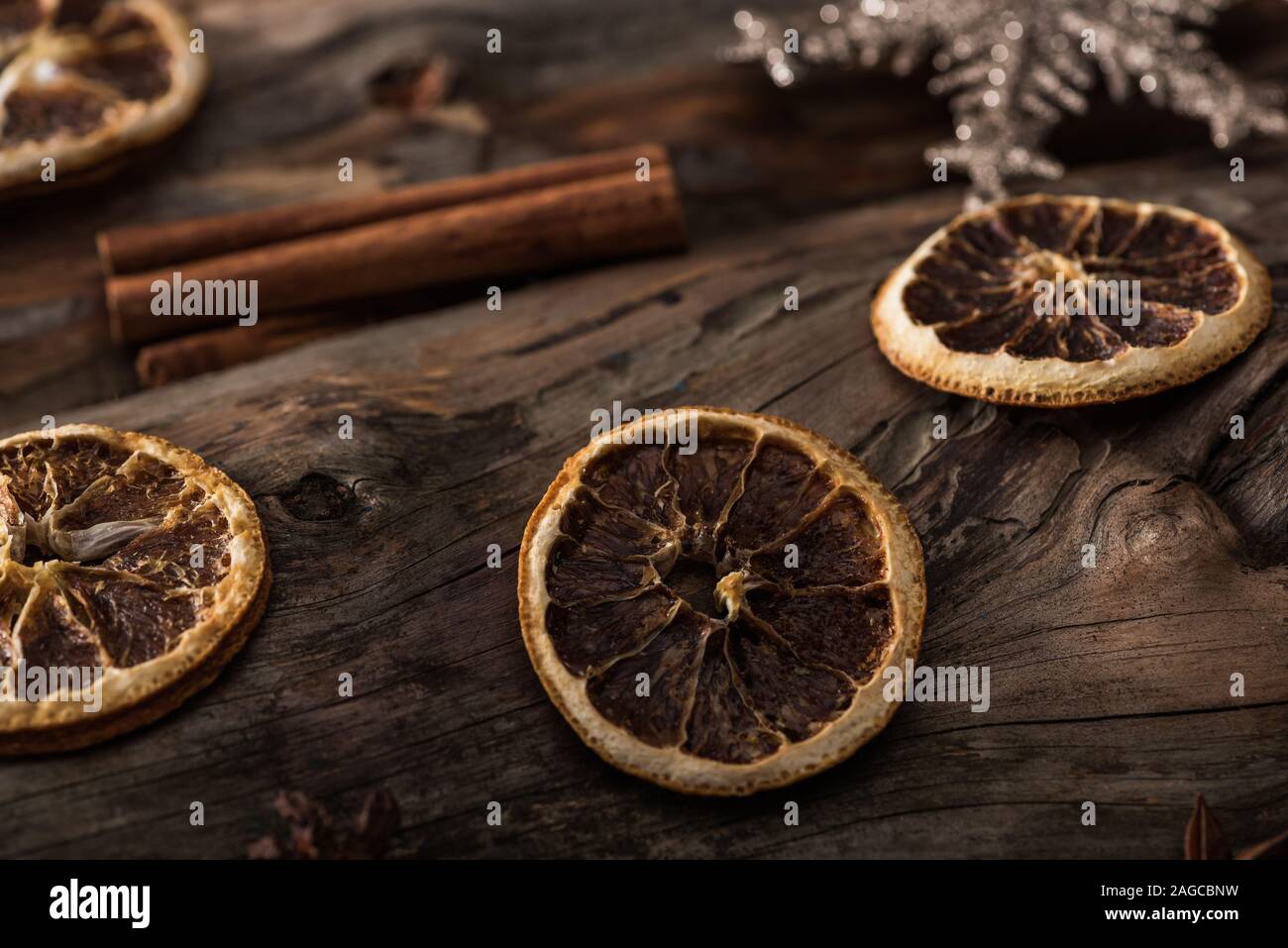 dried citrus slices, cinnamon sticks and decorative snowflake on wooden background Stock Photo
