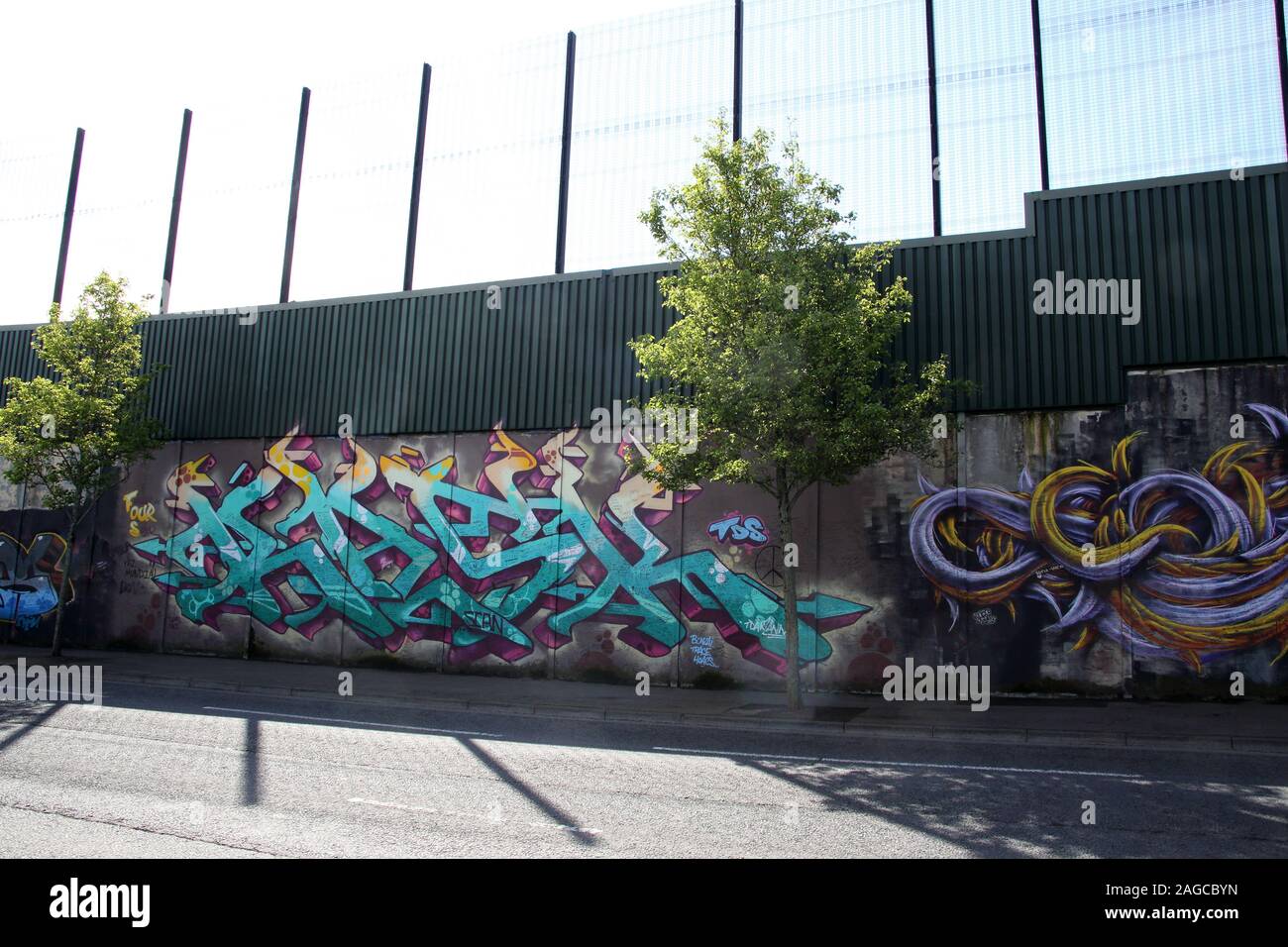 Colourful murals & graffiti on Peace wall,or Peace Line, running along Cupar Way in Belfast. It is one of the many separation barriers in N.Ireland Stock Photo