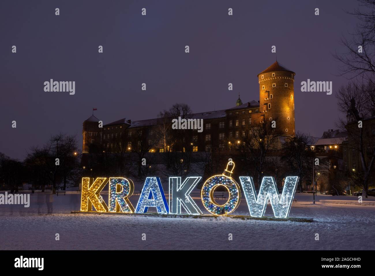 The luminous inscription 'Kraków (Cracow)' composed of Christmas motifs against the background of the Wawel Castle, Cracow, Poland Stock Photo