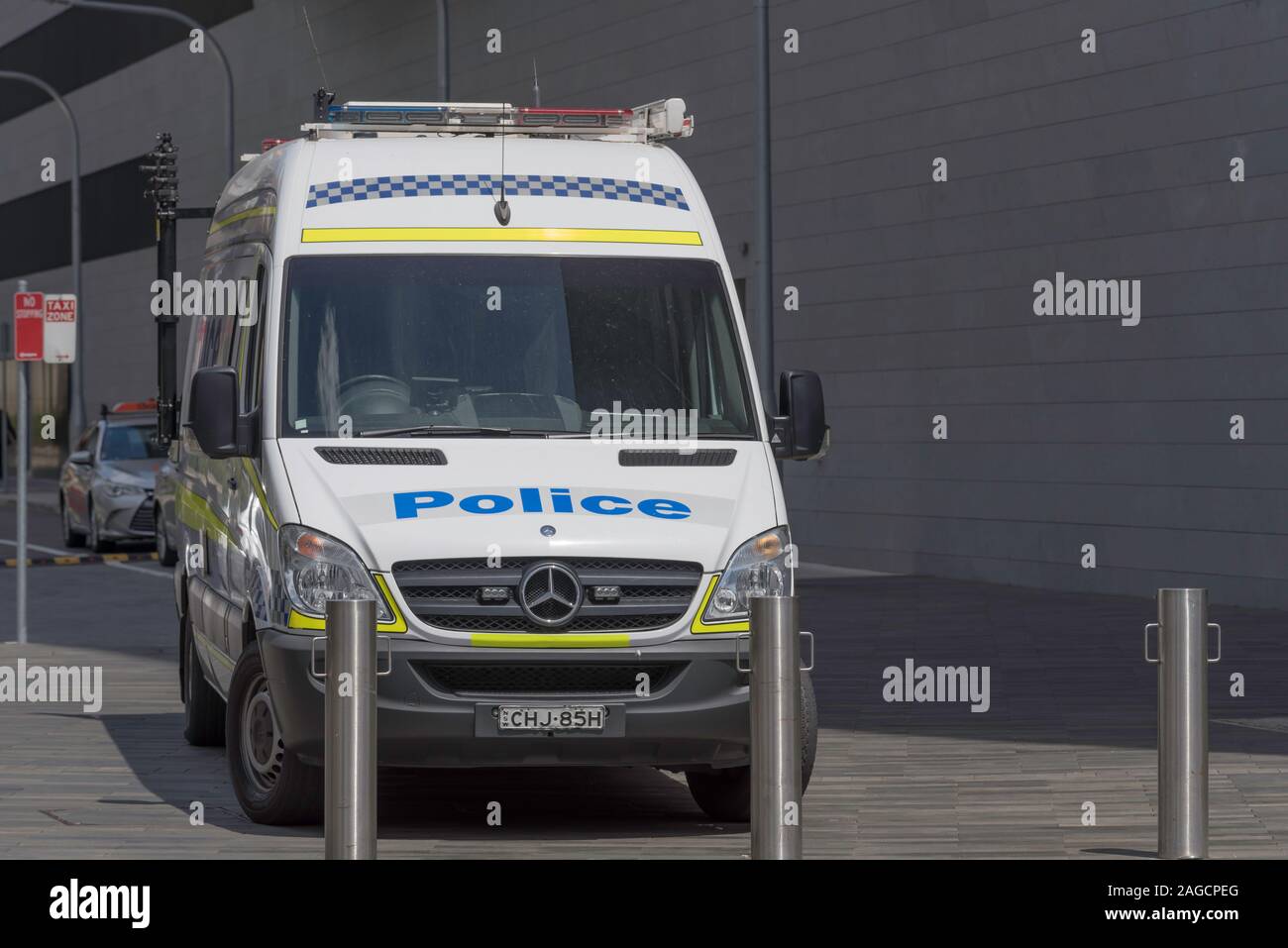 The word Police written in large blue letters on the front of a van or truck parked behind bollards in Sydney, Australia Stock Photo