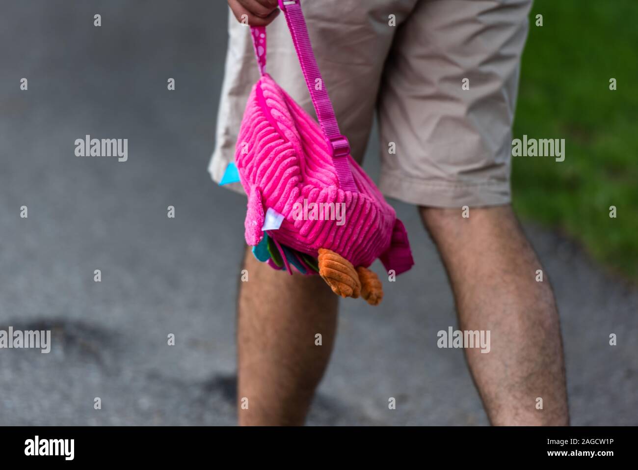 Dad walking with pink rucksack of his daughter trough the park in his ...