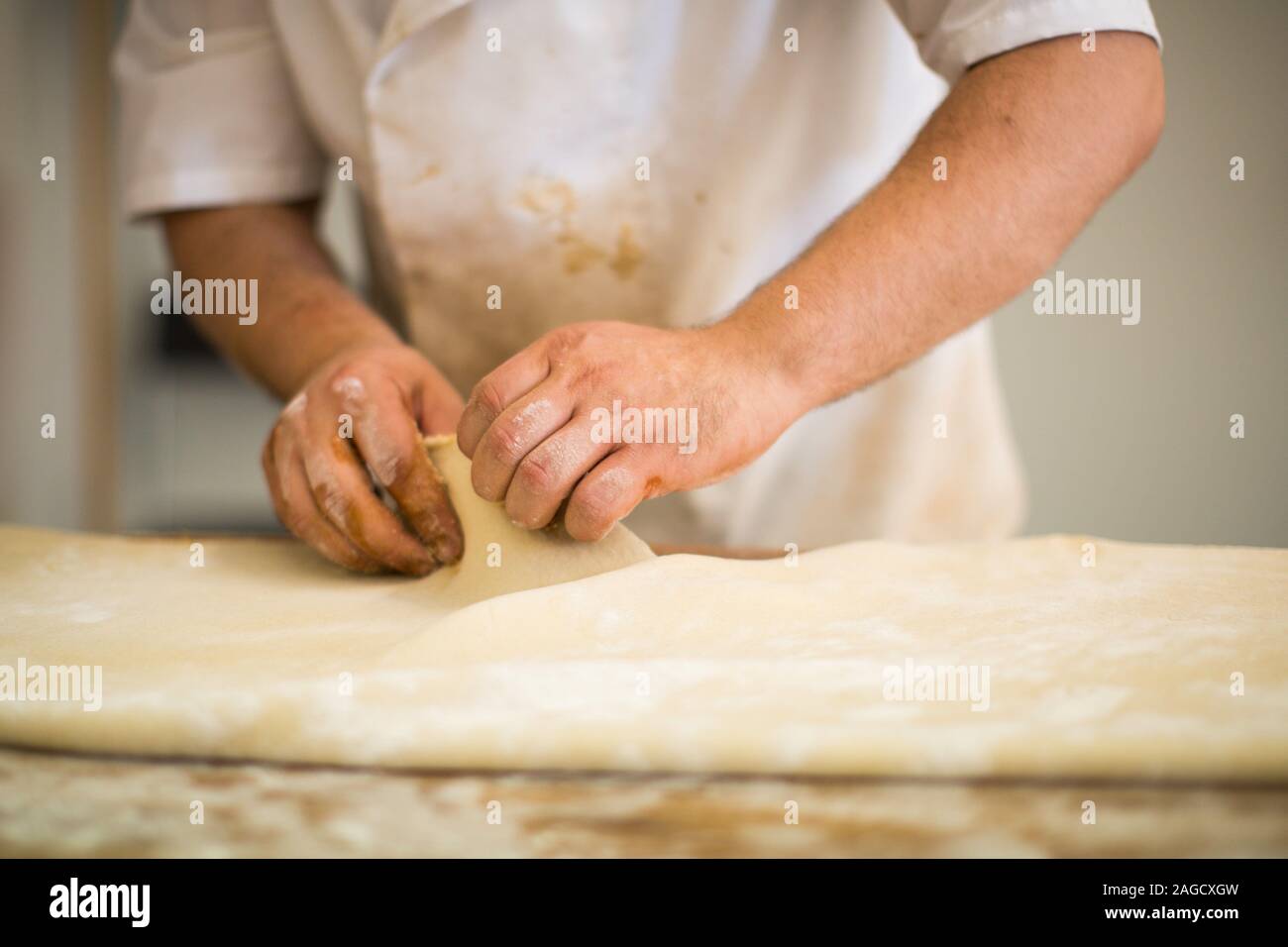 Professional chief making a pastry with dough in a kitchen Stock Photo ...