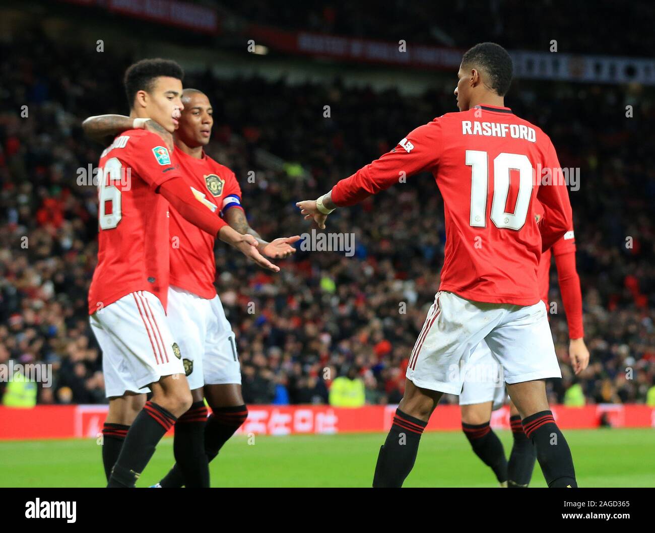 18th December 2019; Old Trafford, Manchester, Lancashire, England; English Football League Cup Football, Carabao Cup, Manchester United versus Colchester United; Mason Greenwood of Manchester United celebrates with team mates Ashley Young and Marcus Rashford of Manchester United after his cross forces an own goal by Ryan Jackson of Colchester United - Strictly Editorial Use Only. No use with unauthorized audio, video, data, fixture lists, club/league logos or 'live' services. Online in-match use limited to 120 images, no video emulation. No use in betting, games or single club/league/player p Stock Photo