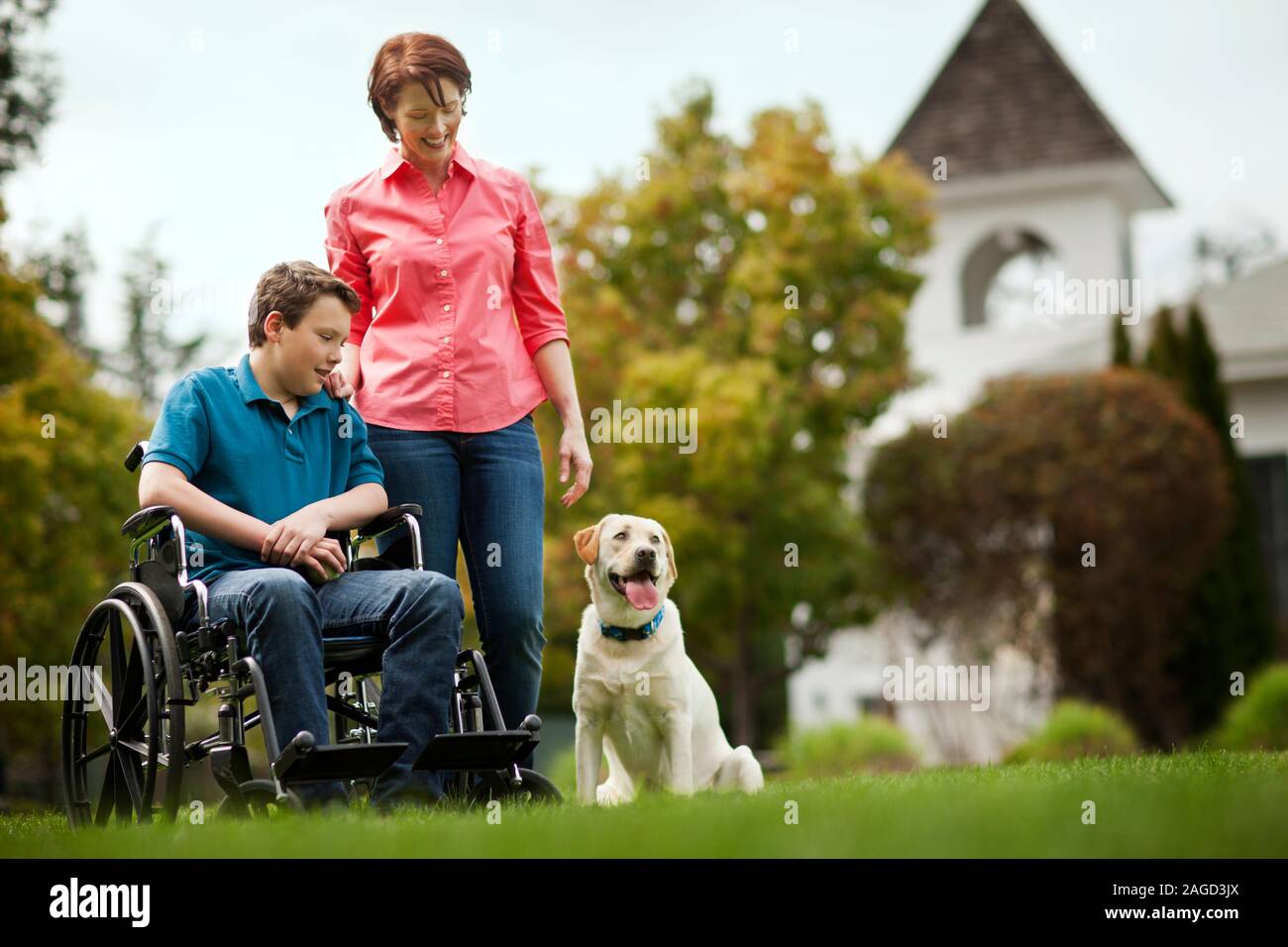 Mid adult woman standing next to her teenage son in a wheelchair. Stock Photo