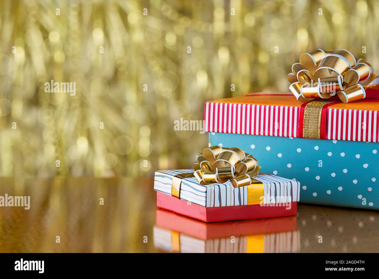 Two gift boxes with bows on a gold blurred background. Holiday concept ...