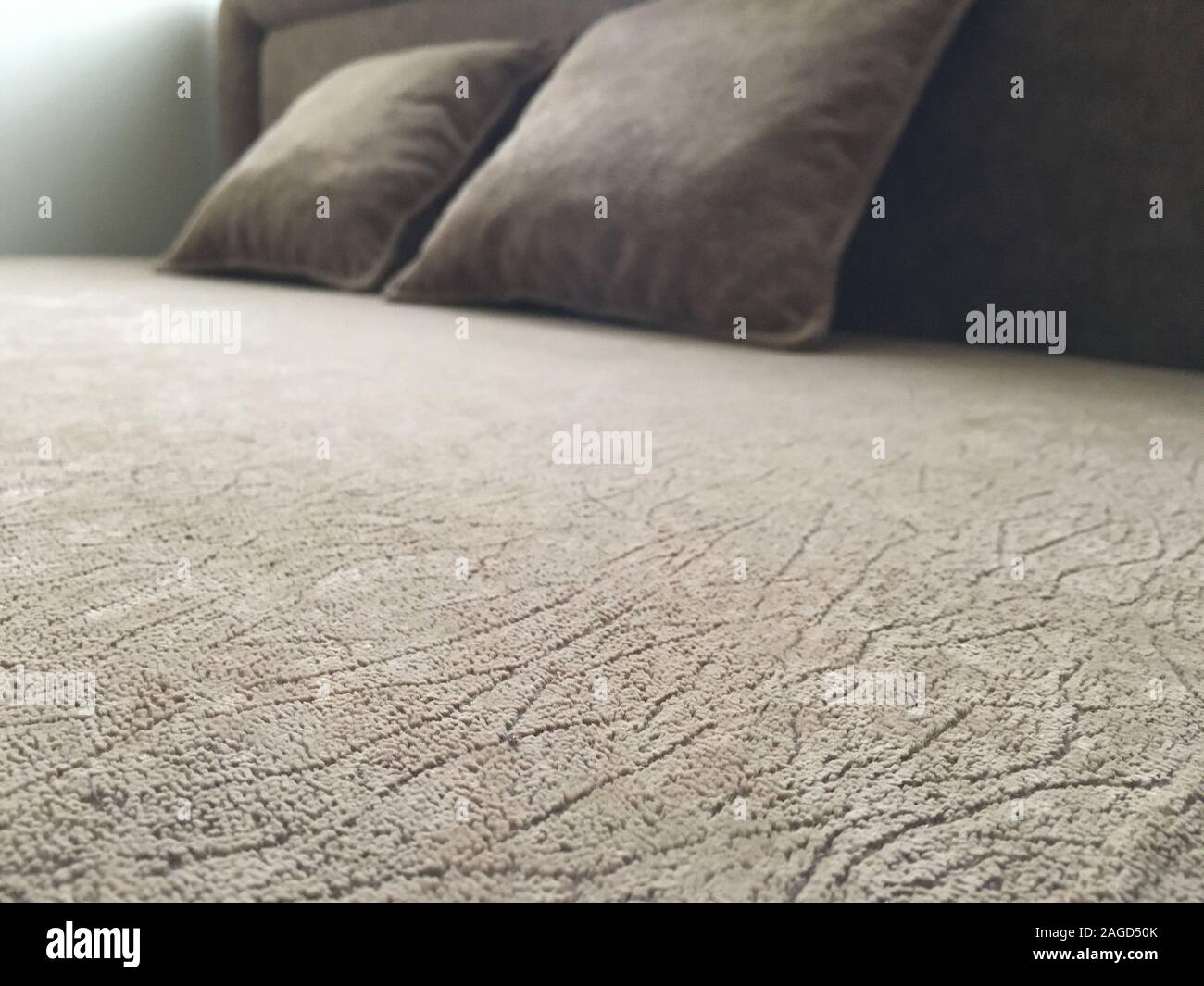 A Closeup Of A Furry Grey Blanket On A Big Bed With Two Square