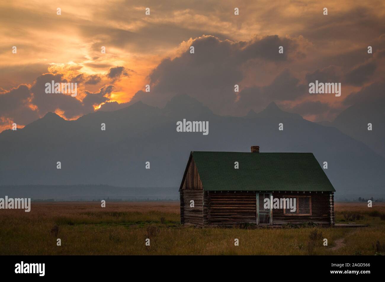 Cute scenery of the sun setting over a country house in the middle of a farm Stock Photo