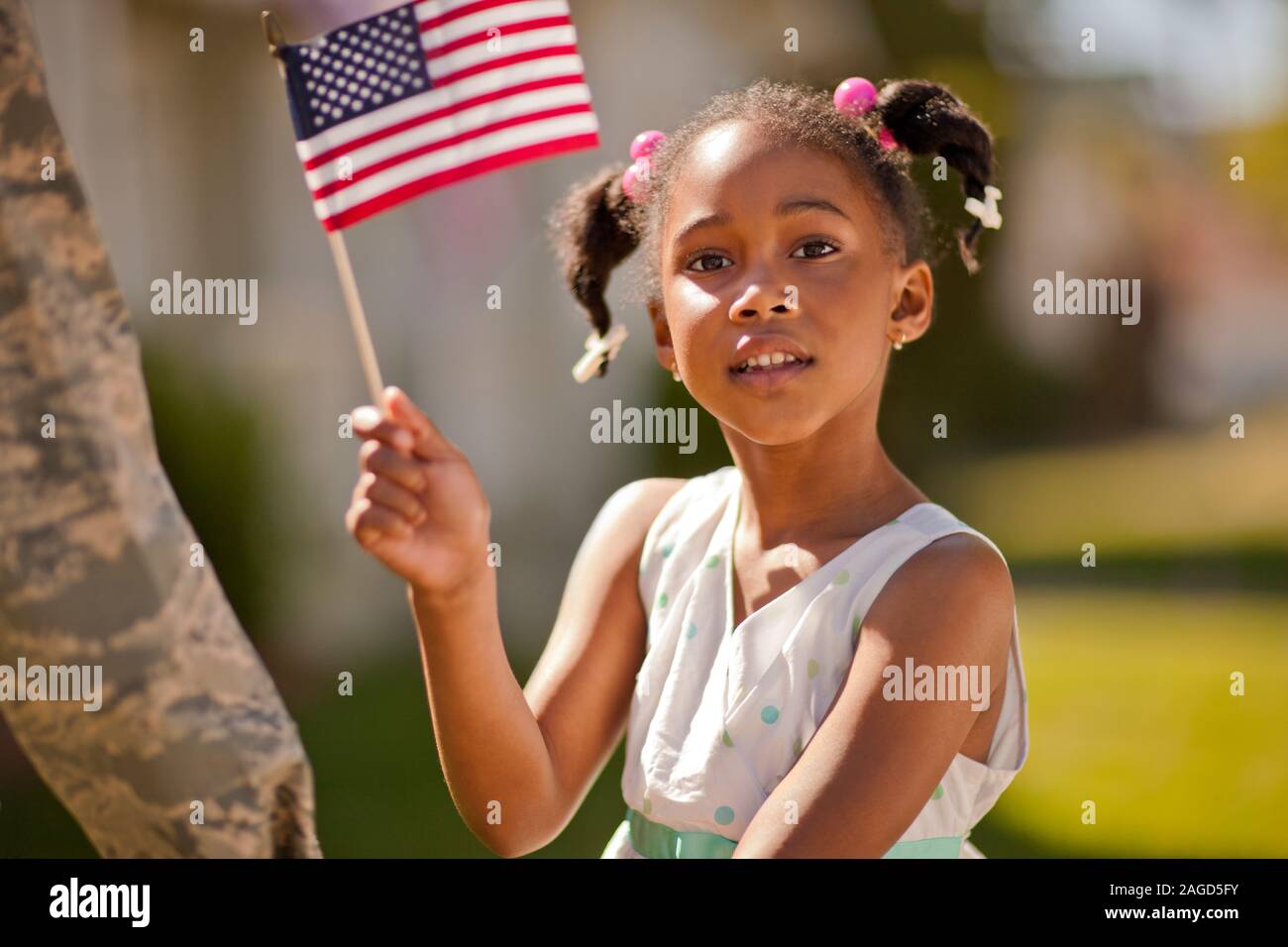 Portrait of a young girl waving an American flag. Stock Photo