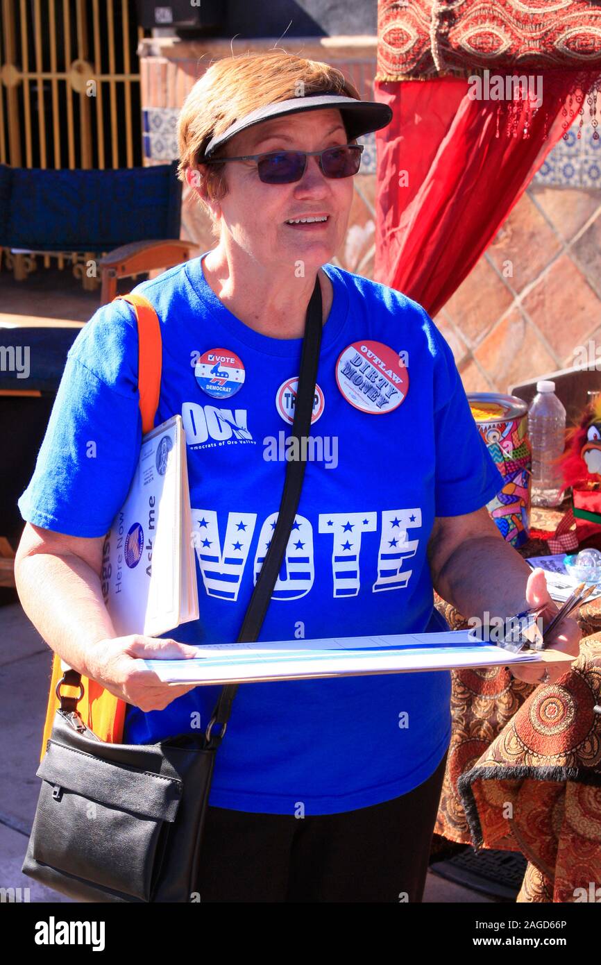 Woman in her vote blue t-shirt asking people if they are registered to vote in the 2020 election in Tucson, AZ Stock Photo