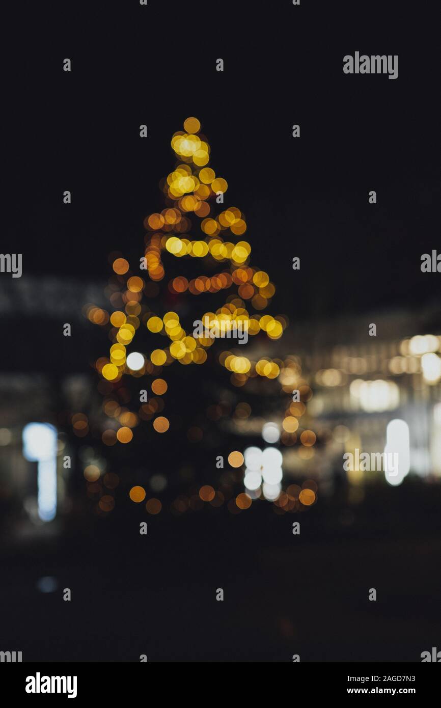 Vertical picture of a Christmas tree with blurry lights during the ...