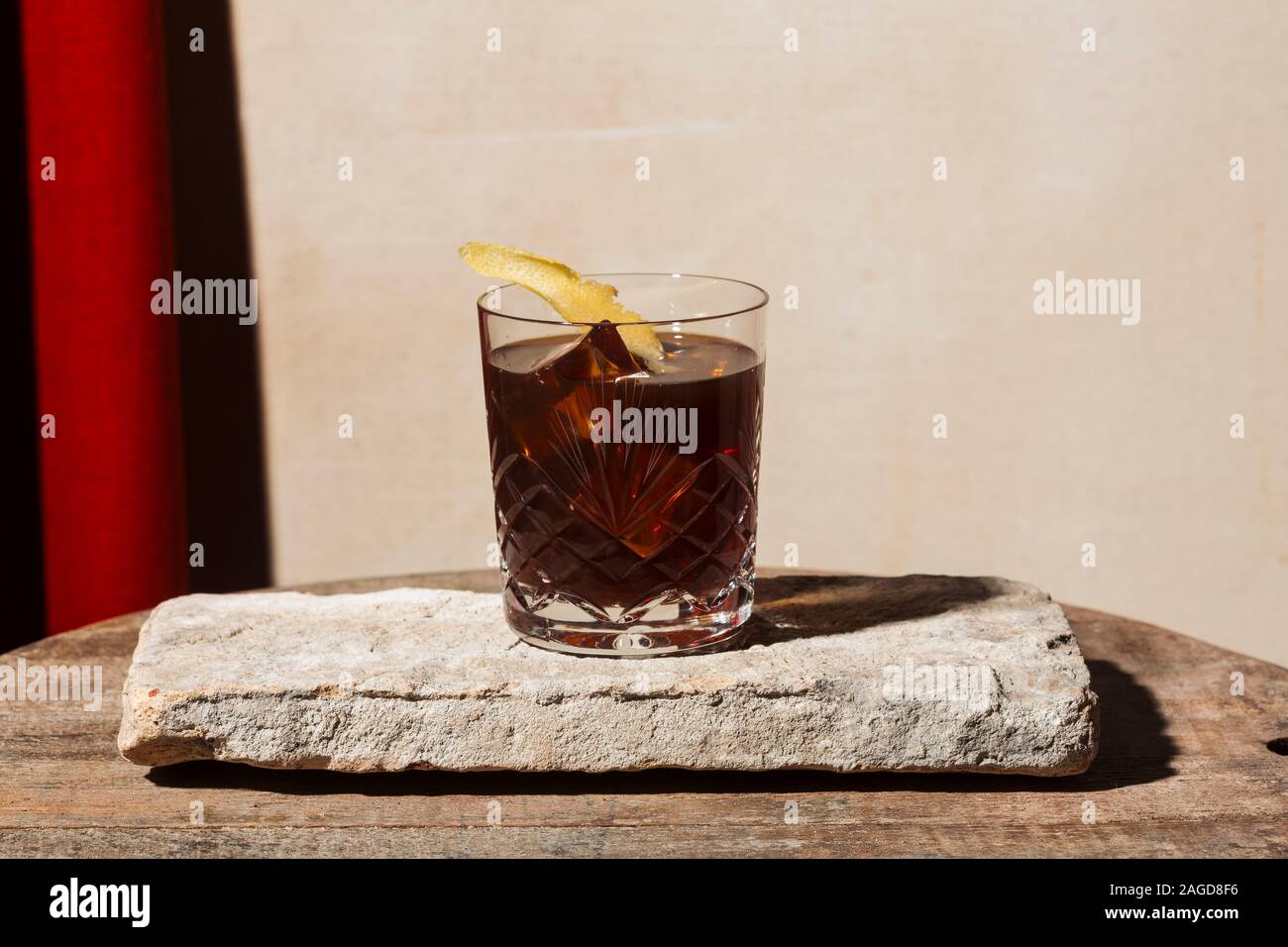 Negroni cocktail with red vermut, gin and bitter, garnished with lemon