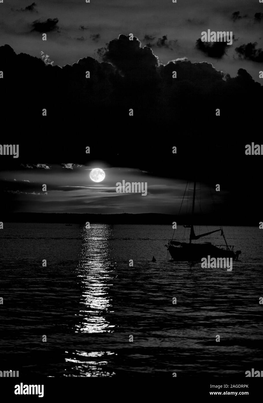 Greyscale Shot Of A Ship In The Sea Under The Dark Cloudy Sky With The
