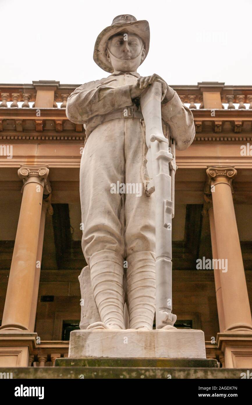 Newcastle, Australia - December 10, 2009: Closeup of white statue of soldier resting on rifle at WW1 35th infantry battalion memorial. Silver sky and Stock Photo