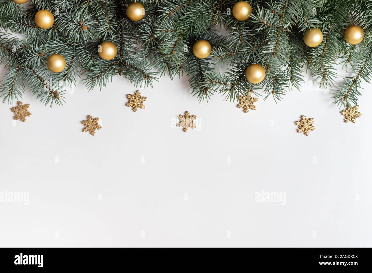 Christmas frame with fir branches, golden snowflakes and balls on a ...