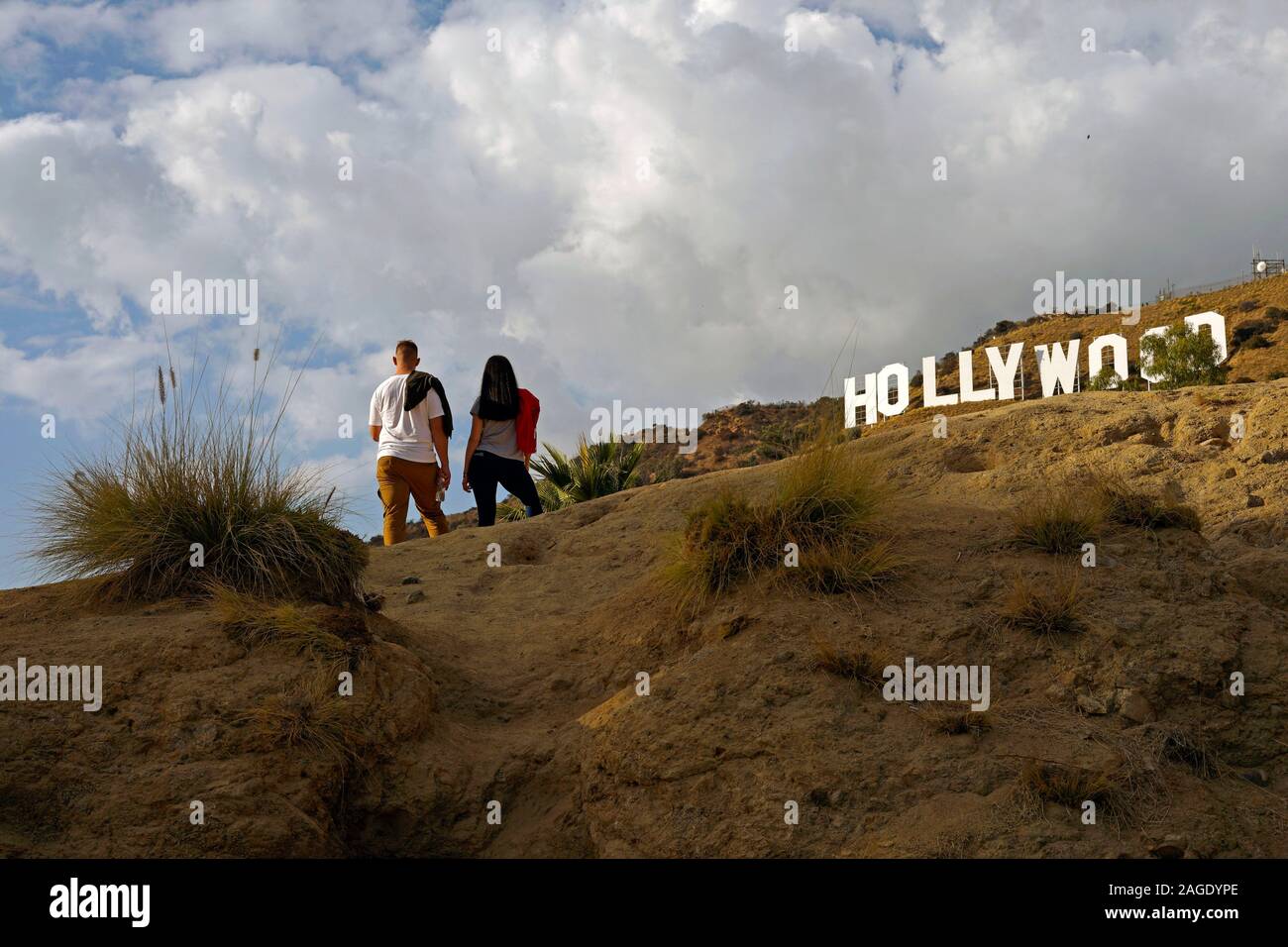 a young couple hiking in Hollywood's Griffith Park stop to admire the famous  Hollywood sign Stock Photo