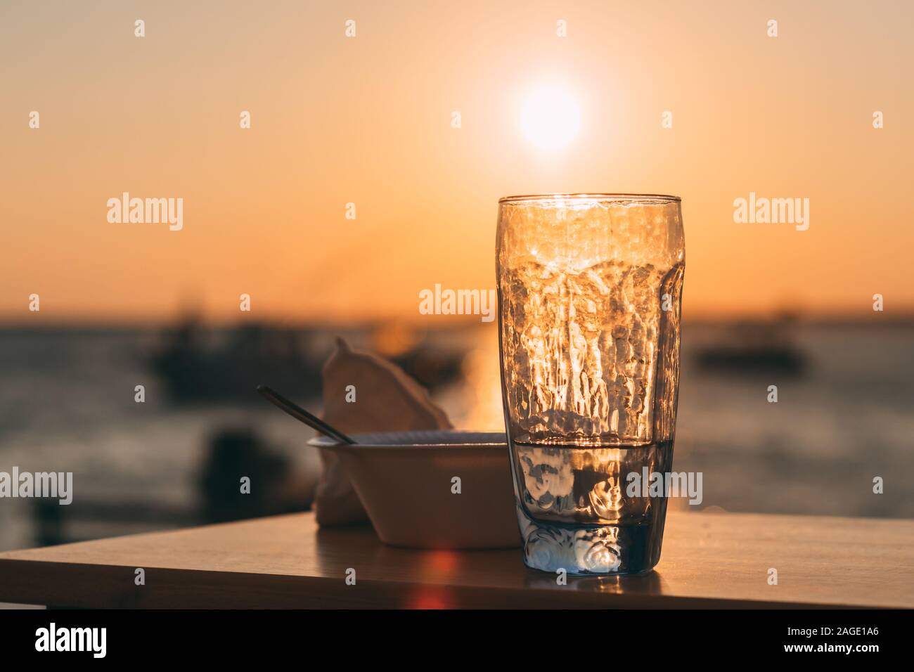 Glass Cup Filled With Water And A Bowl On A Table With The Beautiful View Of Sunset In Background Stock Photo Alamy