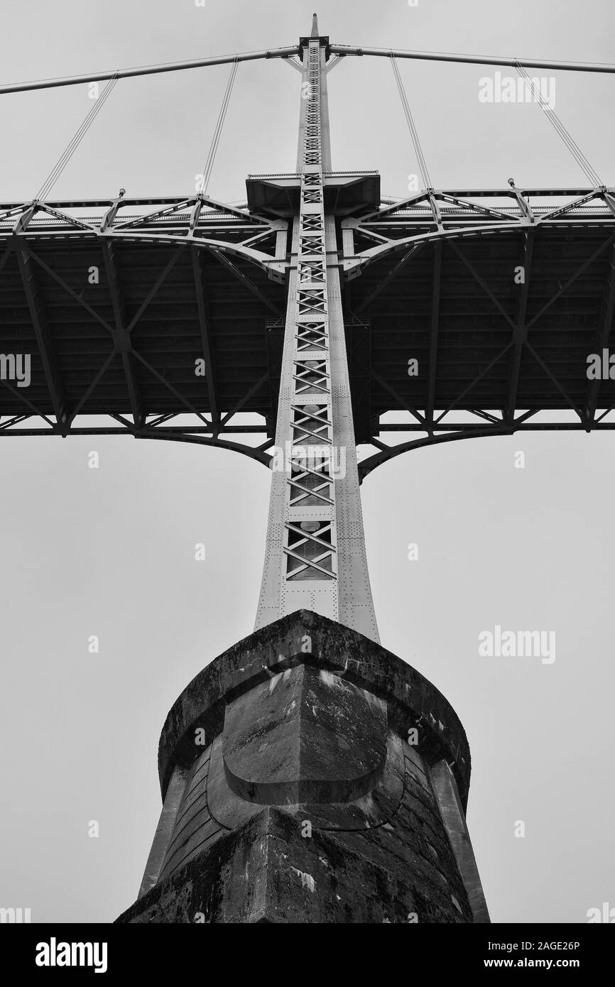 PORTLAND, UNITED STATES - Oct 05, 2019: A vertical grey scale shot of the metal columns and cables of a bridge captured from a low angle Stock Photo